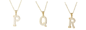 Detail of gold-plated P, Q, R letter pendants with sparkling inlaid rhinestones