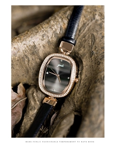 Close-up of rose gold oval watch with crystal bezel on a textured bark background