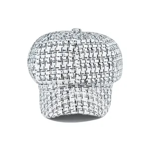 Classic black and white tweed newsboy cap with vintage herringbone texture and button top