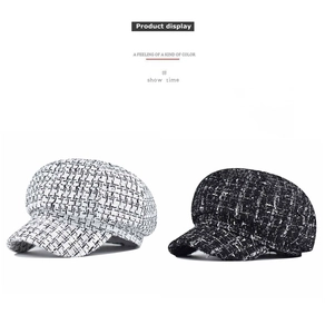 Detailed view of tweed newsboy caps with contrast weave and short brim design