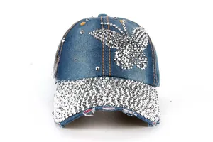 Detail of denim baseball cap featuring crystal butterfly and rhinestone covered brim