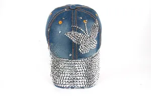 Detail of blue denim baseball cap with rhinestone butterfly and studded brim accents