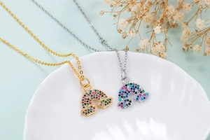 Detailed macro shot of gold and silver rainbow cloud pendants with colorful zircon inlay