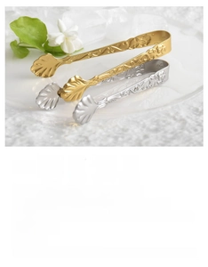 Detailed relief of vintage rose pattern on shell-shaped stainless steel ice tongs