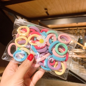 Colorful elastic hair ties in a transparent pouch featuring a small daisy print