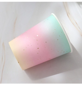Detail of disposable paper cup with rainbow gradient and gold foil polka dots for parties