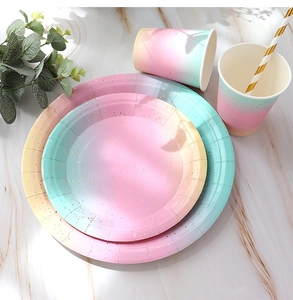 Detail view of rainbow gradient paper plates and cups with gold foil polka dots for parties