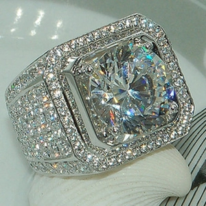 Macro detail of silver ring with round center stone and square halo diamond pave setting