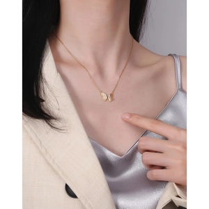 Collier avec pendentif papillon doré en argent sterling S925 porté par un mannequin
