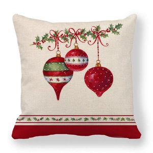 Close-up of linen Christmas pillowcase with festive red baubles and holly leaf prints