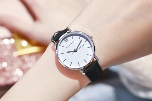 Nahaufnahme der minimalistischen Uhr mit römischen Ziffern und schwarzem Lederband