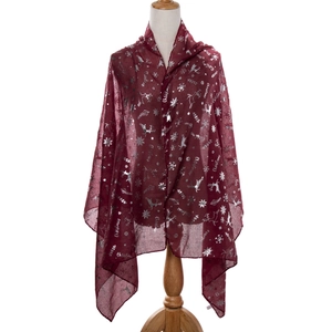Detail view of silver foil Christmas reindeer and snowflake patterns on a burgundy scarf