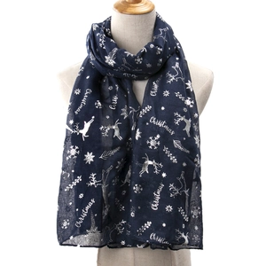 Dark blue Christmas scarf with silver reindeer and snowflake prints on a mannequin