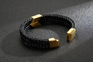 Close-up of double-layer black braided leather bracelet with golden magnetic clasp