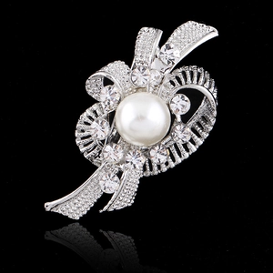 Elegant silver flower brooch featuring a white pearl and sparkling rhinestones on black base