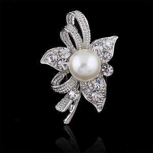 Elegant silver flower brooch with white pearl and crystal rhinestones on black reflection
