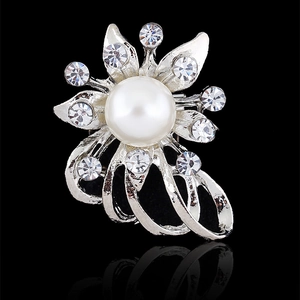Detailed close-up of a silver flower brooch with a central pearl and crystal accents