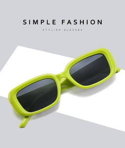 Dettaglio ravvicinato di occhiali da sole rettangolari verde neon con lenti scure e stile chic