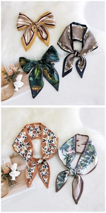 Detail view of five assorted silk-feel skinny scarves featuring leopard and floral patterns