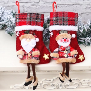 Detail von Weihnachtssocken mit Weihnachtsmann und Schneemann auf einem weißen Kamin