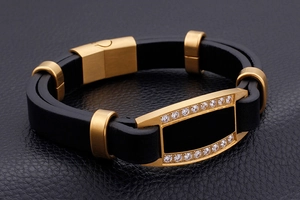 Detail of men's black leather bracelet with gold-plated metal and inlaid cubic zirconia