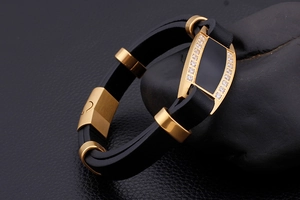 Macro shot of men's black leather bracelet with gold-plated clasp and zircon stones