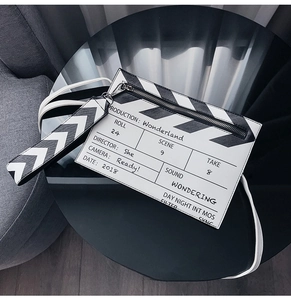 Close-up of movie clapperboard pattern design on a black and white crossbody bag