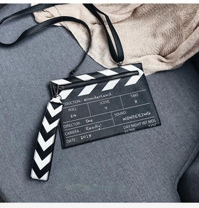 Detail of clapperboard pattern shoulder bag with white printed text and stripe strap