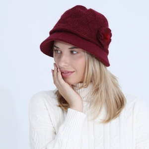Detail of wine red knitted floral hat with elegant flower decor and soft texture
