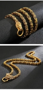 Detailed close-up of golden titanium steel byzantine chain with lion head clasp design