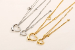 Detailed view of heart pendant necklaces in gold and silver with double chain design