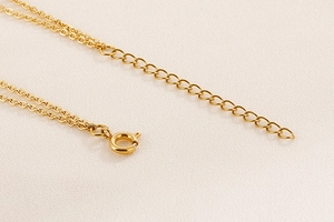 Detailed macro view of golden stainless steel chain link with a durable lobster clasp