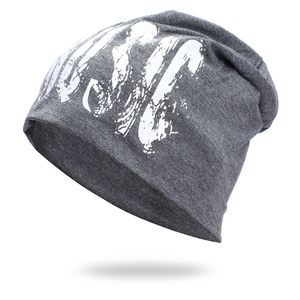 Detail of grey slouchy beanie with white graffiti print and soft knitted texture