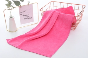 Close-up of rose red microfiber car towel texture on a stylish metal basket