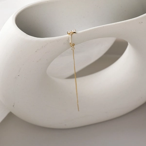 Orecchini a fiocco dorati con nappe di zirconi su supporto in ceramica bianca