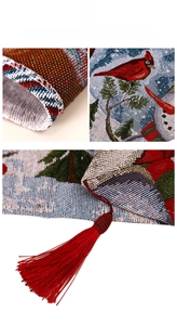 Macro detail of Christmas jacquard table runner with cardinal birds and red tassels
