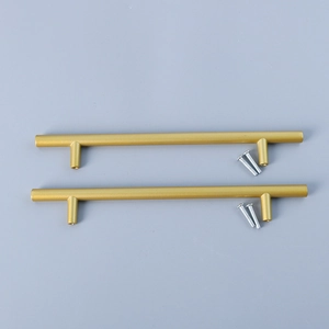 Macro view of matte gold T-bar cabinet handles with four silver mounting screws