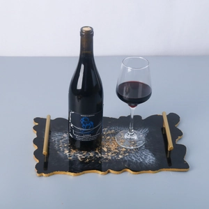 Detailed view of black resin tray with gold foil flakes and golden metal handles
