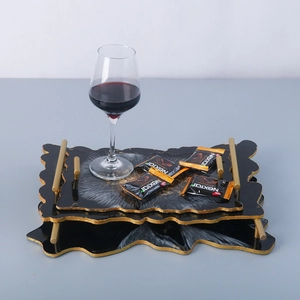 Detail of DIY resin trays with wavy gold edges and sleek cylindrical metal handles