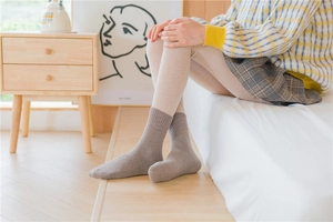 Detailed knit texture of brown mid-calf thermal socks with ribbed cuffs for winter wear