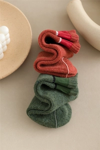 Detail of warm cotton crew socks in rust red and olive green with ribbed knit texture