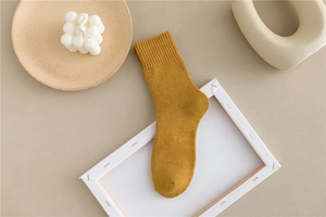 Detailed close-up of thick mustard yellow thermal crew sock with ribbed cuff texture