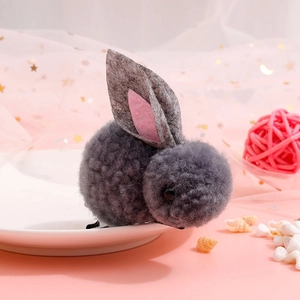 Close-up of cute grey plush rabbit doll with pink ears on a dreamy pink background