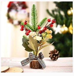 Mini artificial Christmas tree with red berries, pine needles and a natural wood base
