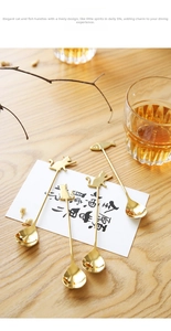 Golden cat and fish handle dessert spoons set on a rustic wooden table setting