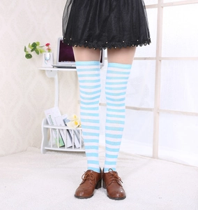 Détail de chaussettes hautes rayées bleu et blanc montrant l'élasticité de la matière