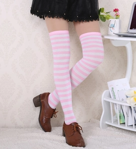 Détail de chaussettes hautes rayées rose et blanc sur modèle en intérieur