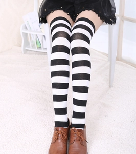 Gros plan de chaussettes hautes rayées noir et blanc portées avec des chaussures en cuir