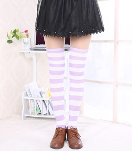Détail de chaussettes hautes à rayures violettes et blanches dans un cadre intérieur