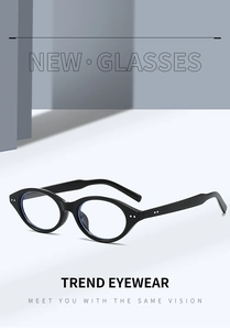 Detail of oval black frame glasses with metallic accents in a minimalist studio setting